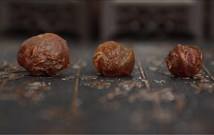 干桂圆与干红枣片在玻璃杯中泡水,背景为木质桌面,自然光线 干桂圆与干红枣片泡水图
