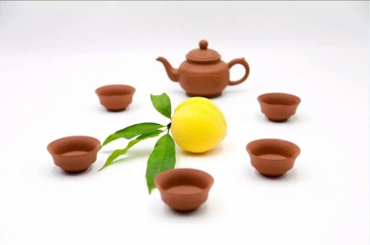 高清微距摄影:展示奉化水蜜桃果肉细胞结构与铁观音干茶表面蜡质层及发酵红变点,强调农产品原料真实性与加工工艺特征 花田乌龙(蜜桃乌龙)原料对比图:左侧为奉化水蜜桃鲜果切面(果肉乳白、汁液丰盈、可见细密维管束)、右侧为安溪铁观音干茶条索(肥壮紧结、砂绿油润、显红点)