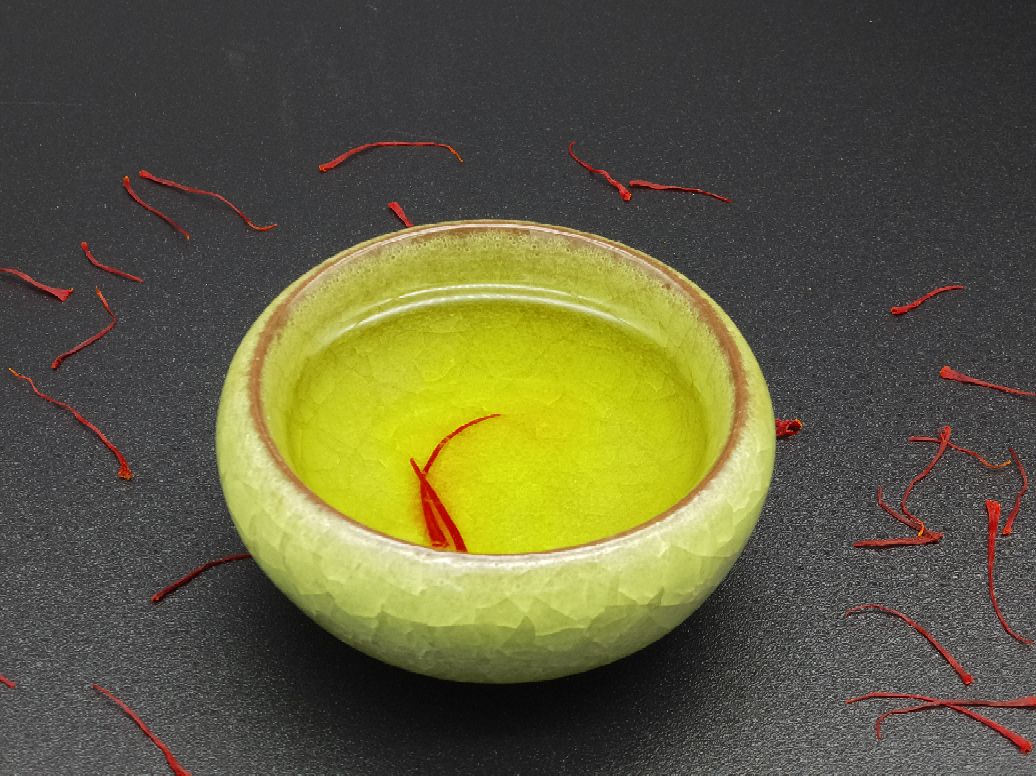 展示藏红花与浙贝母放入玻璃杯中冲泡的实景图,热水刚倒入,药材漂浮,画面温馨自然 泡水场景图