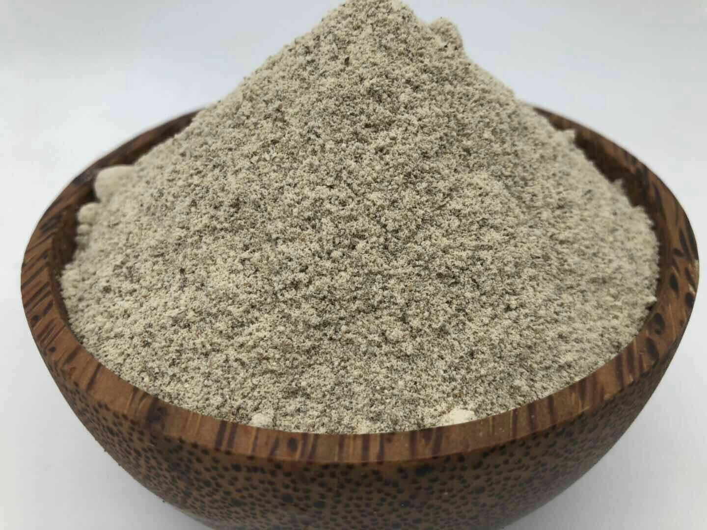 一碗清澈的鸡汤,表面漂浮着少许白色粉末,旁边摆放一小瓶白色胡椒粉和研磨罐,桌上还有切好的生姜片和葱段,体现白胡椒在中式汤品中的典型使用场景 中式菜肴中的白胡椒应用