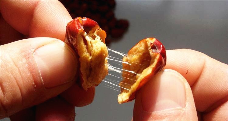 长枣处理特写:三颗去核冷透的乐陵金丝小枣整齐摆放在竹帘上,枣肉饱满呈琥珀色,表面微泛油润光泽,背景虚化可见蒸锅与滤网 长枣处理特写:三颗去核冷透的乐陵金丝小枣整齐摆放在竹帘上,枣肉饱满呈琥珀色,表面微泛油润光泽,背景虚化可见蒸锅与滤网