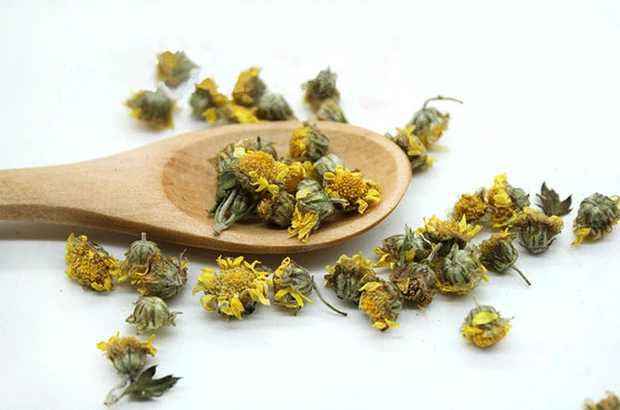 图中展示野菊花与艾草在玻璃壶中煮沸的过程,水汽升腾,散发出淡淡清香 野菊花与艾草煮水的过程图