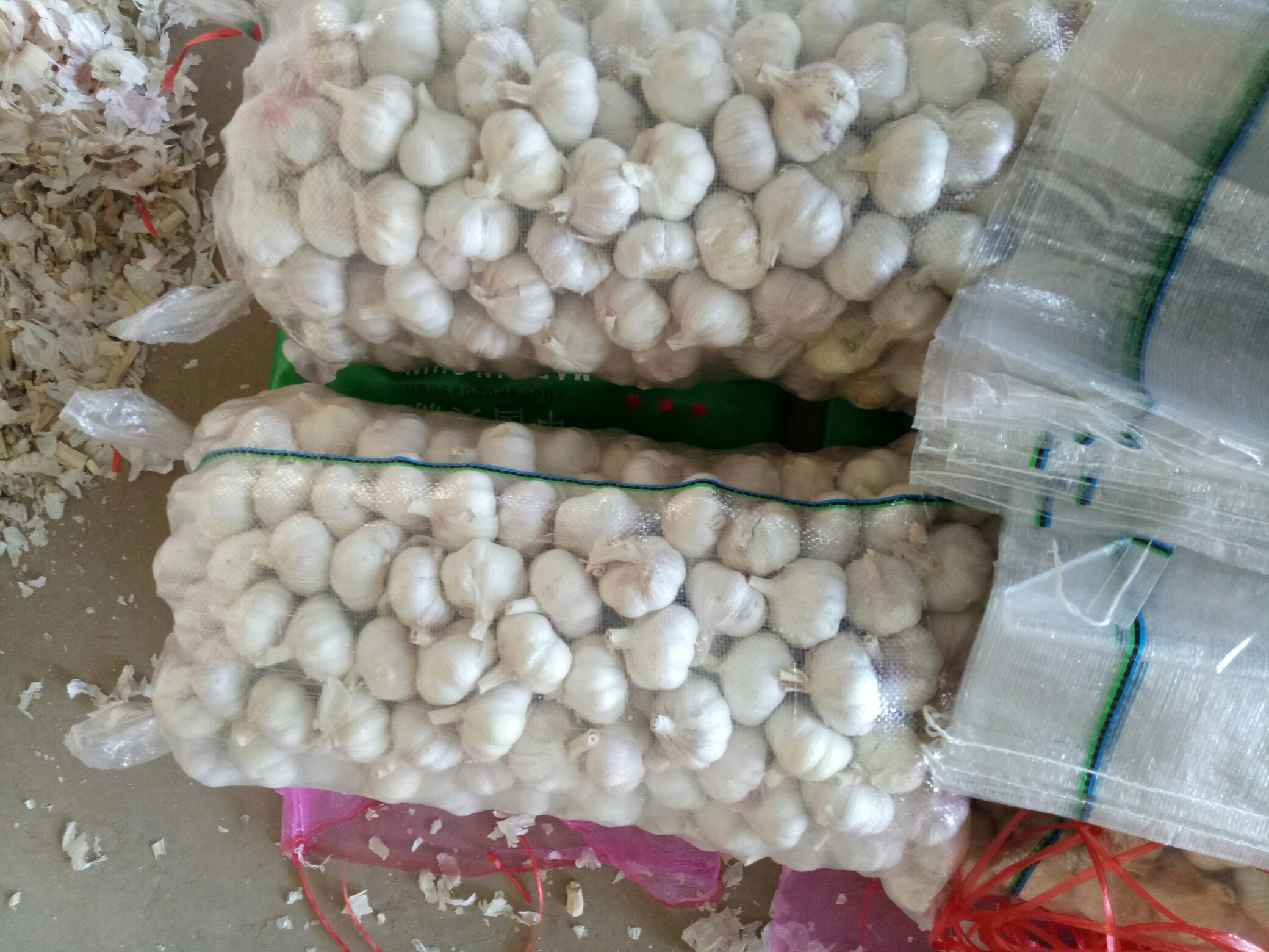 左侧为健康红蒜蒜头,外皮紫红、内瓣洁白;右侧为病理性蒜头发红样本,可见内部蒜瓣出现不规则红色斑点、条纹及局部腐烂迹象,表皮无明显破损但质地软化 蒜头正常与异常发红对比图