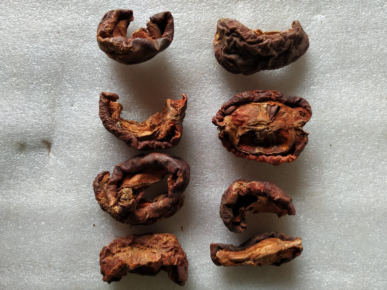 一组三个步骤图展示木瓜皮的处理流程:第一步为新鲜木瓜皮切条,第二步为放在竹筛上自然风干,第三步为装入玻璃瓶密封保存;背景为厨房台面,光线柔和,突出家庭自制的安全与卫生 木瓜皮干燥处理过程示意图