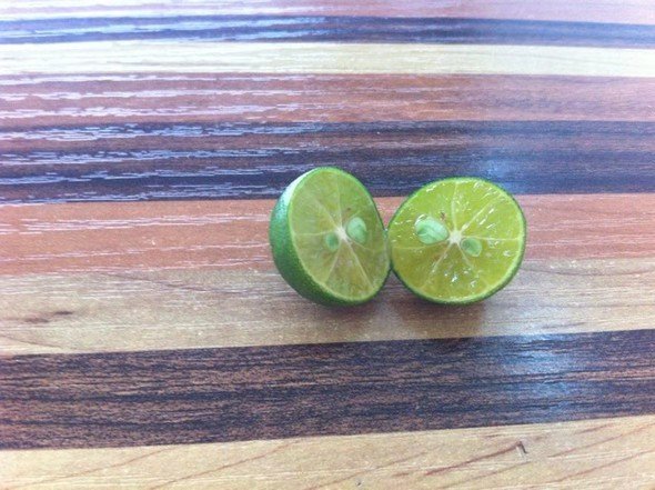 金桔切开展示果肉细节，突出其果肉多汁、色泽金黄的特点