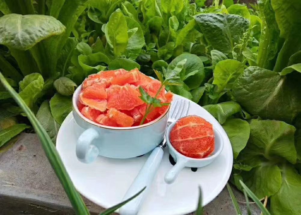 消费者开箱品尝秭归脐橙特写：木质餐桌铺浅灰麻布，打开印有三峡山水图案的礼盒，露出四枚光泽鲜亮的秭归脐橙，一枚已剥开，果瓣饱满晶莹、汁水欲滴，旁边配陶瓷碟盛放果肉，背景虚化处可见窗台绿植与晨光