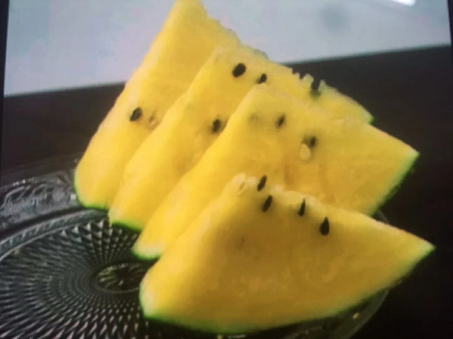 俯拍对比图:白色哑光陶瓷餐盘中并置两块等大西瓜切片,左侧为特小凤西瓜金黄色果肉,色泽饱和温暖,汁水在切面边缘形成细微水珠;右侧为传统京欣红瓤西瓜,红色鲜亮但略带粉调,籽粒较多;两者旁置一小勺蜂蜜与薄荷叶作风味呼应,突出‘黄金甜’主题 特小凤西瓜果肉与红瓤西瓜对比摆拍