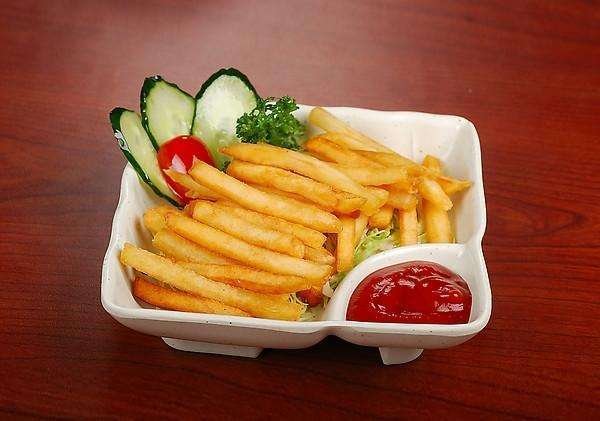 薯龙薯条盛放在盘中,周围摆放番茄酱、酸奶酱、辣椒酱等不同蘸料 薯龙薯条搭配多种酱料摆盘展示