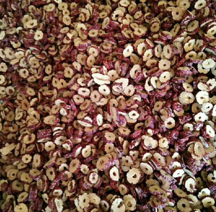 干红枣片的特写镜头,展示其切片形态与自然色泽,背景为木质桌面,营造健康食品的氛围 干红枣片特写