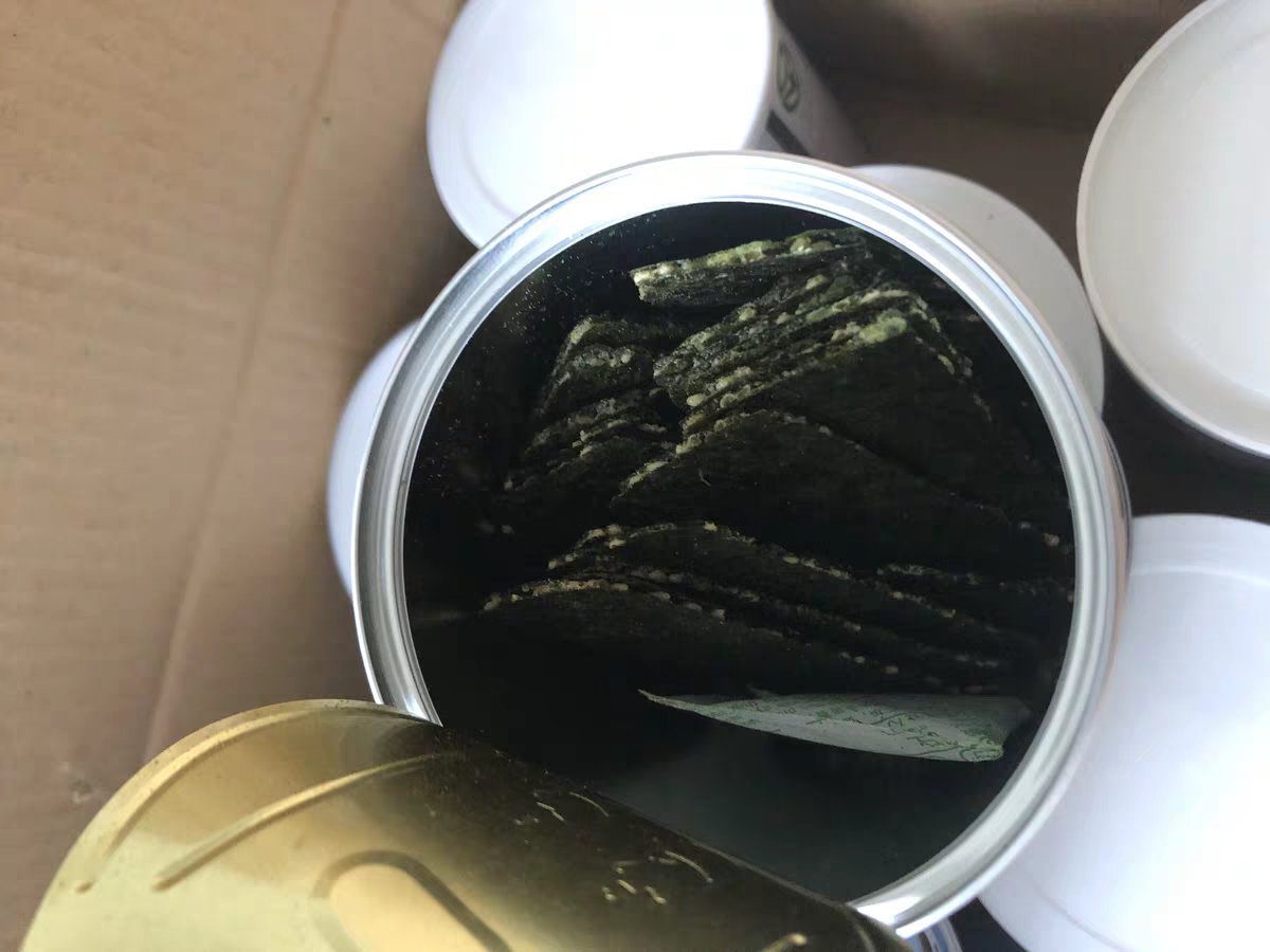 透明玻璃罐内盛放金棕色烤脆枣,颗粒饱满匀称,表面泛自然油润光泽;罐口已抽真空封口,旁边放置一包蓝色硅胶干燥剂,背景为木质料理台 真空密封的烤脆枣玻璃罐特写