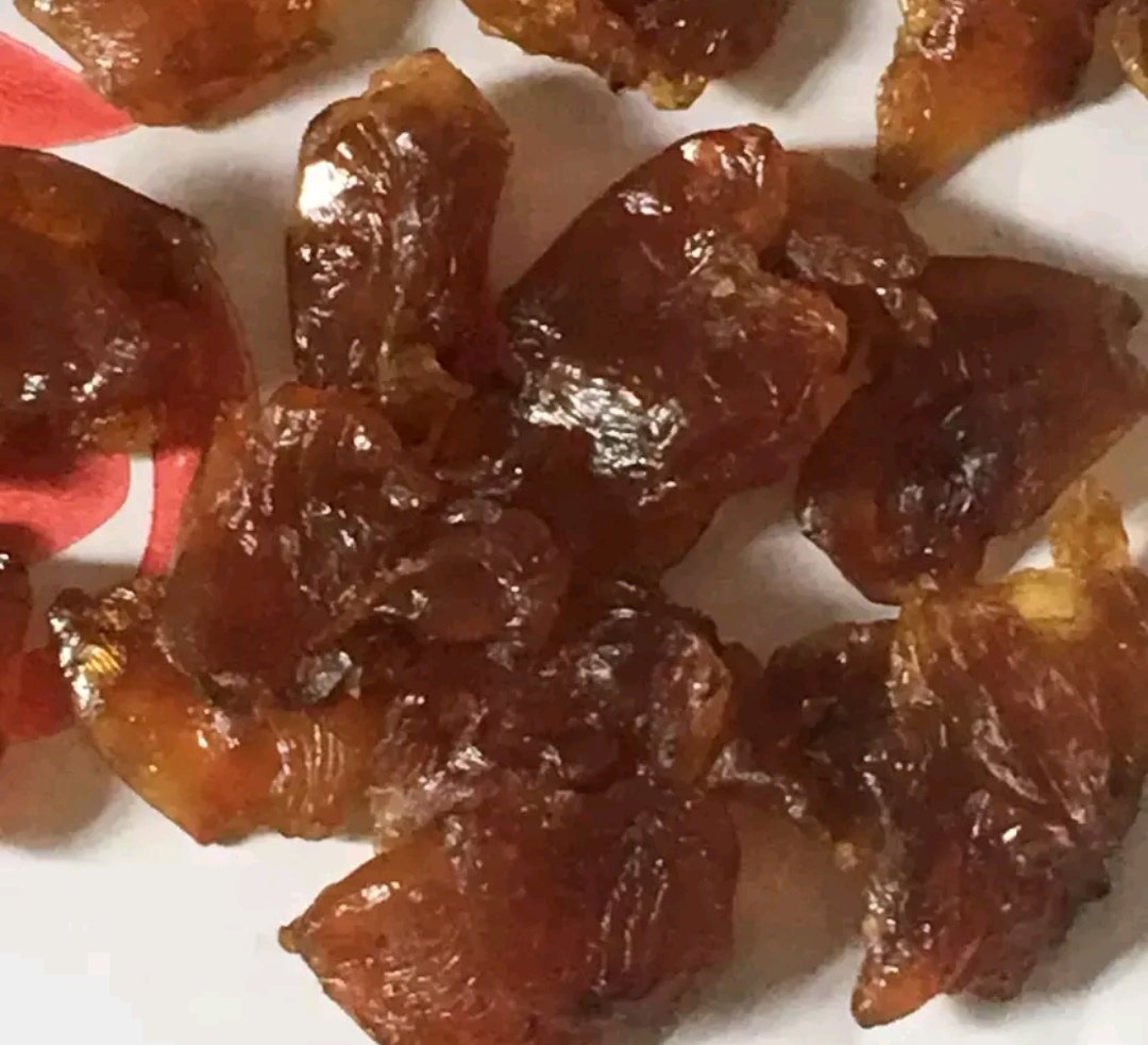 桂圆干实物特写：浅棕色半透明果肉，表面微皱有光泽，整齐铺陈于白色陶瓷盘中，背景为木质砧板与不锈钢厨房秤（显示10.0g读数）