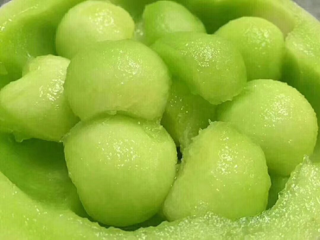 对比图：左侧为完整玉菇甜瓜（带网纹青灰绿外皮），右侧为去皮去籽后乳白果肉块，置于玻璃碗中，表面凝结细密水珠，凸显高水分特性