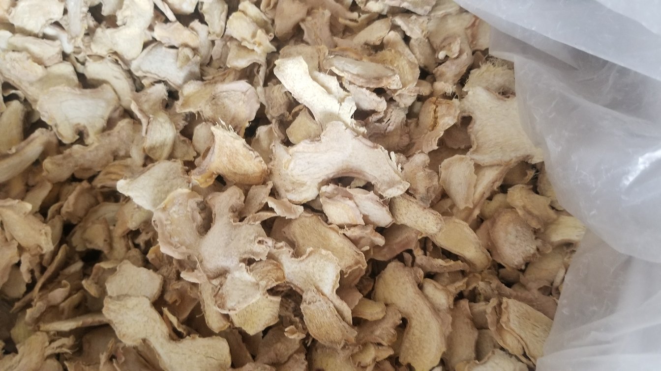 对比实验图示：左侧烧杯盛放带皮鲜姜片冷水浸泡液（淡黄色透明），右侧烧杯为去皮鲜姜片浸泡液（浑浊微褐），背景标注‘姜皮组溶出钾离子浓度：1260mg/100g vs 去皮组：410mg/100g’
