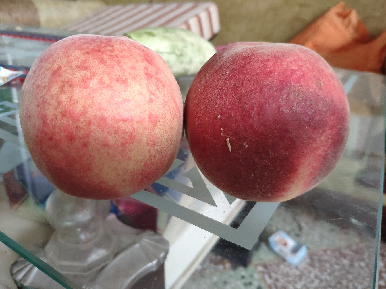 切开的新鲜桃子放在木质砧板上，露出金黄色果肉和深红色果核，旁边有一把不锈钢水果刀，背景模糊呈现厨房环境