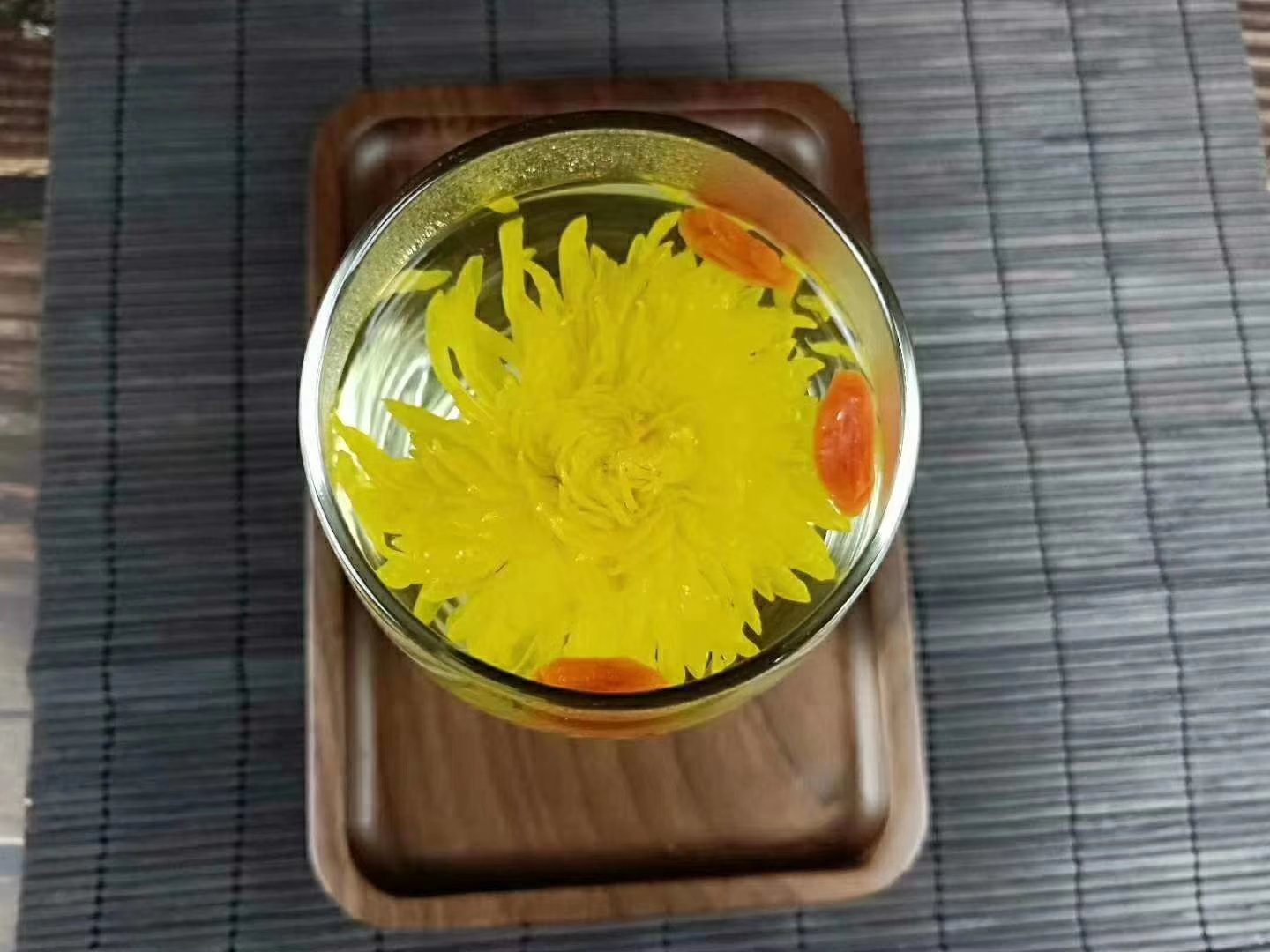 展示冲泡过程中菊花舒展、柠檬片浮于水面的状态,茶汤呈淡黄色 金丝皇菊与柠檬片泡水冲泡过程图