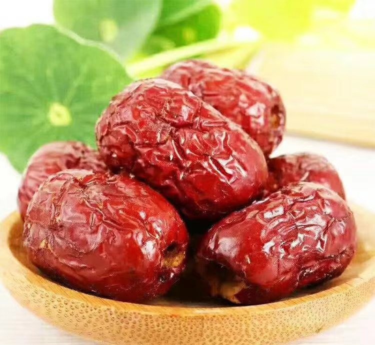 冷冻后的鲜枣表面结霜，正在用手剥离外皮