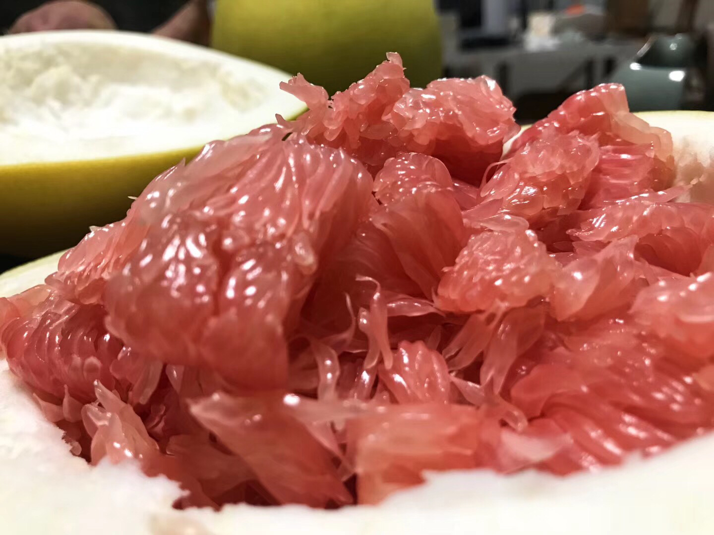 高清微距摄影:展示西蜜柚典型粉红果肉、致密汁胞排列及果皮厚度特征,背景为四川安岳标准化果园标识牌 西蜜柚横切特写:粉红色果肉清晰可见汁胞结构,表面覆薄层白色海绵层,果皮厚约1.2cm,呈淡黄绿色带细微油胞点