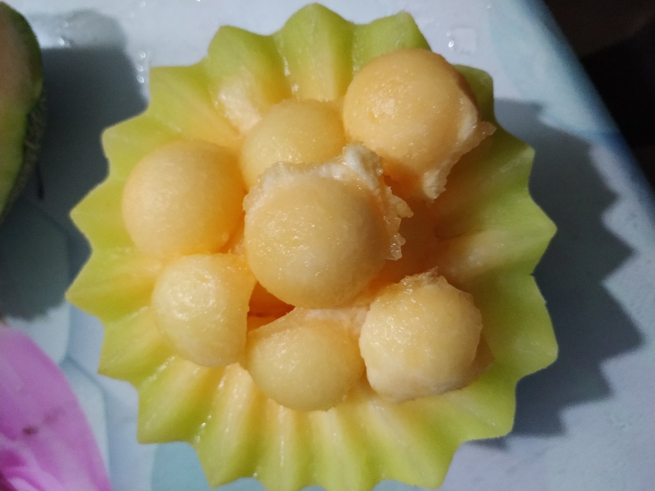 翠梨甜瓜切片摆放在果盘中，旁边搭配其他水果，整体呈现清新自然的风格