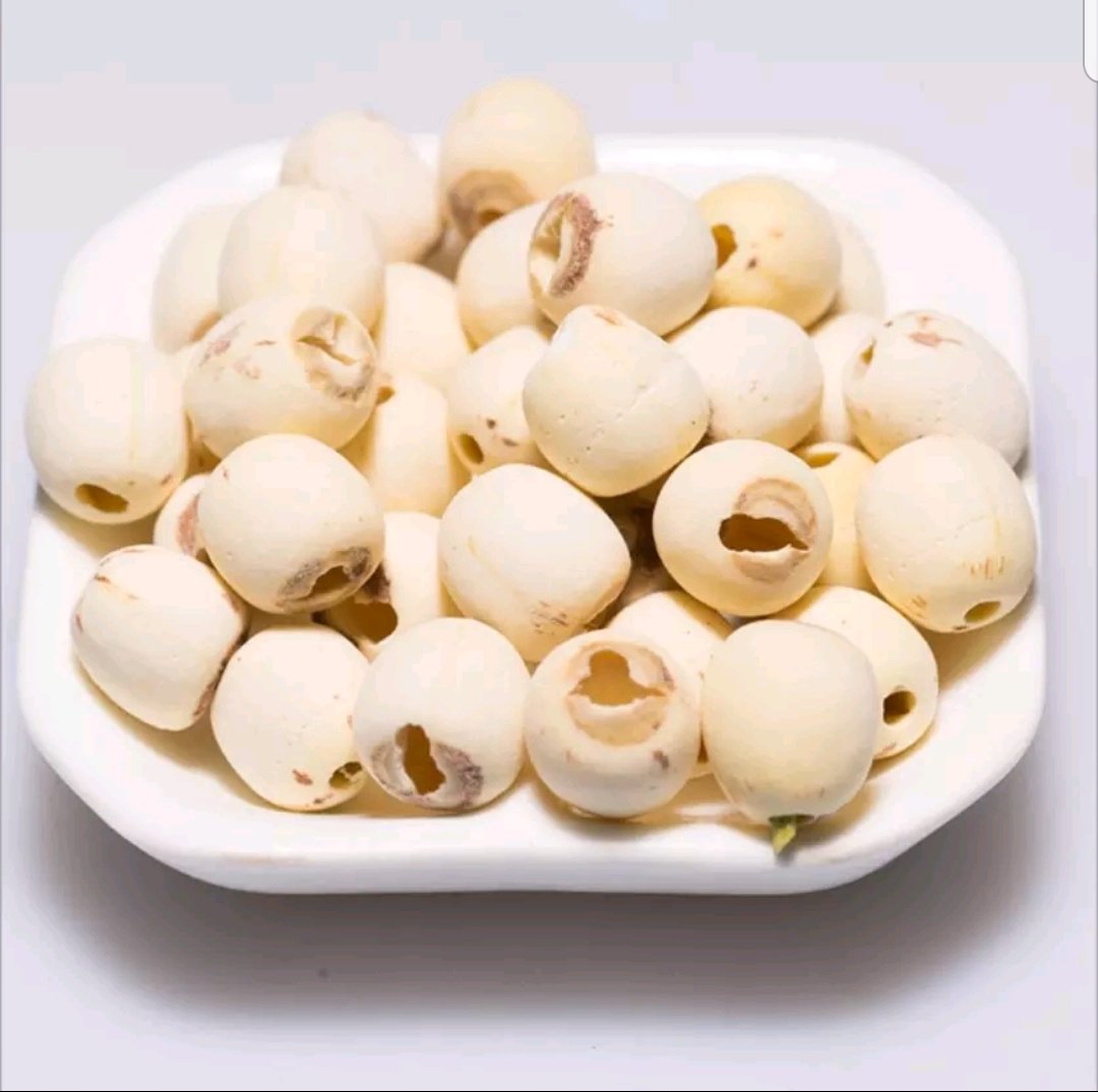 展示一盘洁白饱满的湘莲干果,背景为湖南田园风光 湘莲的外观展示