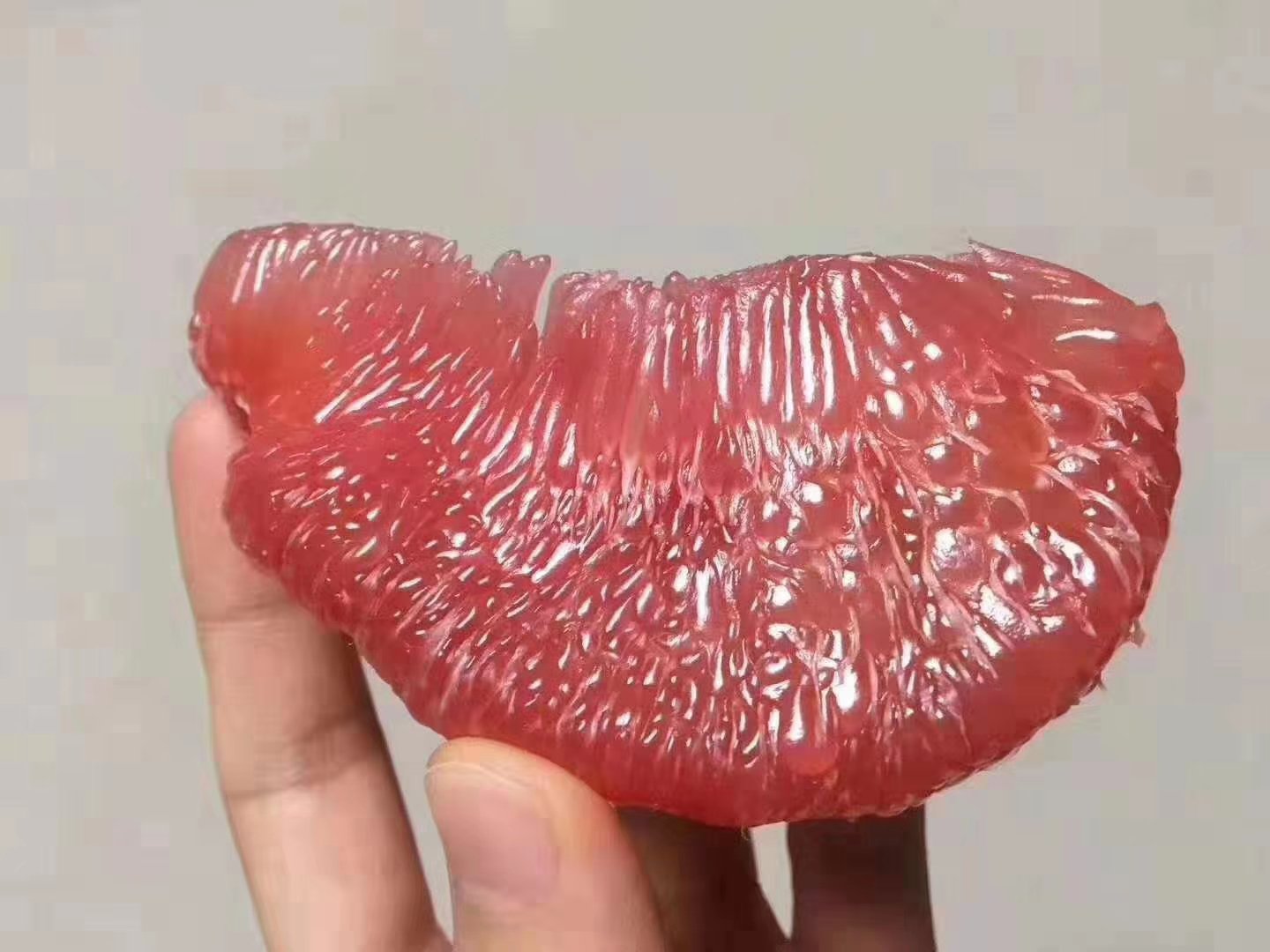三种当季柚子果肉实拍:琯溪蜜柚果肉晶莹剔透、红心西柚果肉粉嫩饱满、沙田柚果肉米白微透,展现不同品种最佳成熟期的质地与色泽差异 厨房台面上摆放三个玻璃碗:左碗盛放剥好的琯溪蜜柚果肉(晶莹半透明)、中碗为红心西柚果肉(粉红诱人)、右碗为沙田柚果肉(米白微透),各配一小勺,背景为木质砧板与不锈钢刀具,体现即食新鲜感