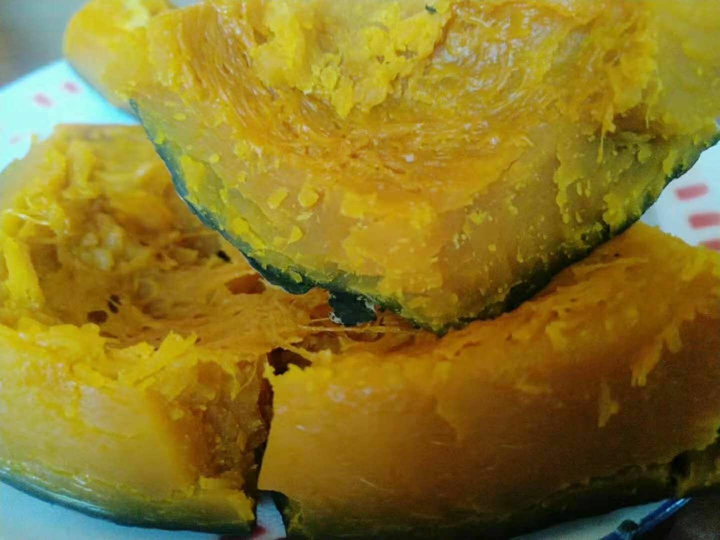 一个成熟的板栗南瓜被横向切开,露出金黄色的瓜瓤和中心排列整齐的种子,瓜肉色泽均匀,背景为木质砧板,自然光线照射,突出食材新鲜质感 板栗南瓜切开特写