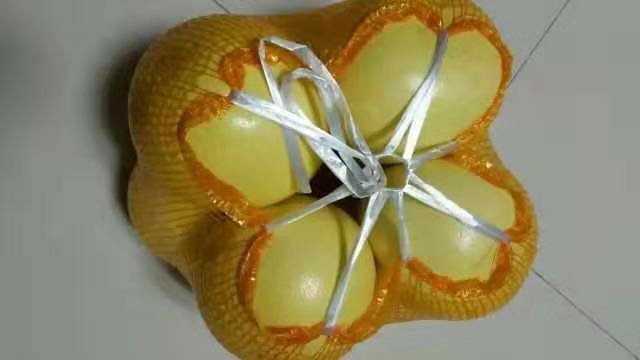 一组精美的琯溪蜜柚礼盒陈列在木质桌面上,礼盒设计融合闽南文化元素,印有‘平和琯溪蜜柚’地理标志图案;打开的礼盒内整齐摆放4个去蒂清洗后的蜜柚,部分已切开展示红心与白心果肉对比;周围点缀柚子叶和书法字体标签,营造高端礼品氛围 琯溪蜜柚礼盒包装展示