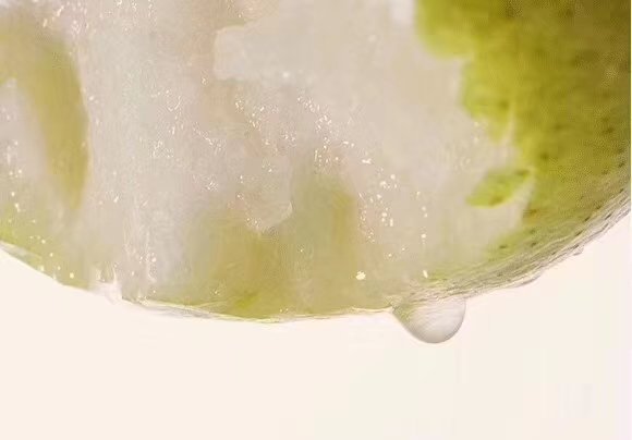 一张高清特写照片,展示切开的新鲜小香梨,果肉洁白细腻,汁水充盈,剖面光滑无渣,旁边放置一把不锈钢水果刀和一块白色陶瓷盘,背景虚化 图片描述