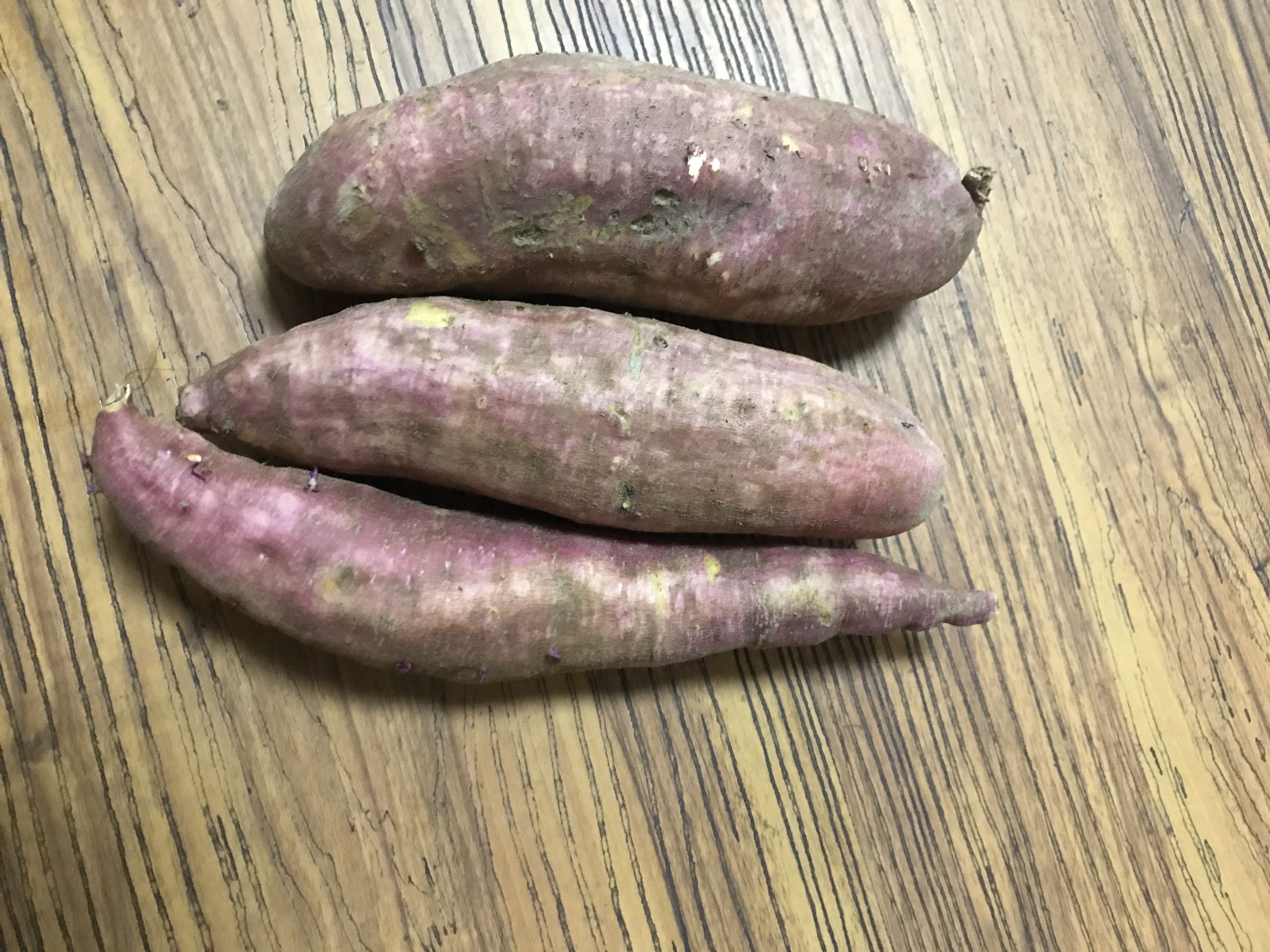 一张木质餐桌上摆放着一盘蒸熟的切块黄心红薯,旁边配有全麦面包、水煮蛋和一小碟凉拌菠菜,体现均衡膳食理念 家庭餐桌上的红薯料理