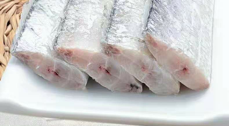 新鲜带鱼摆放在案板上,鱼身银白,体态细长 带鱼实物图