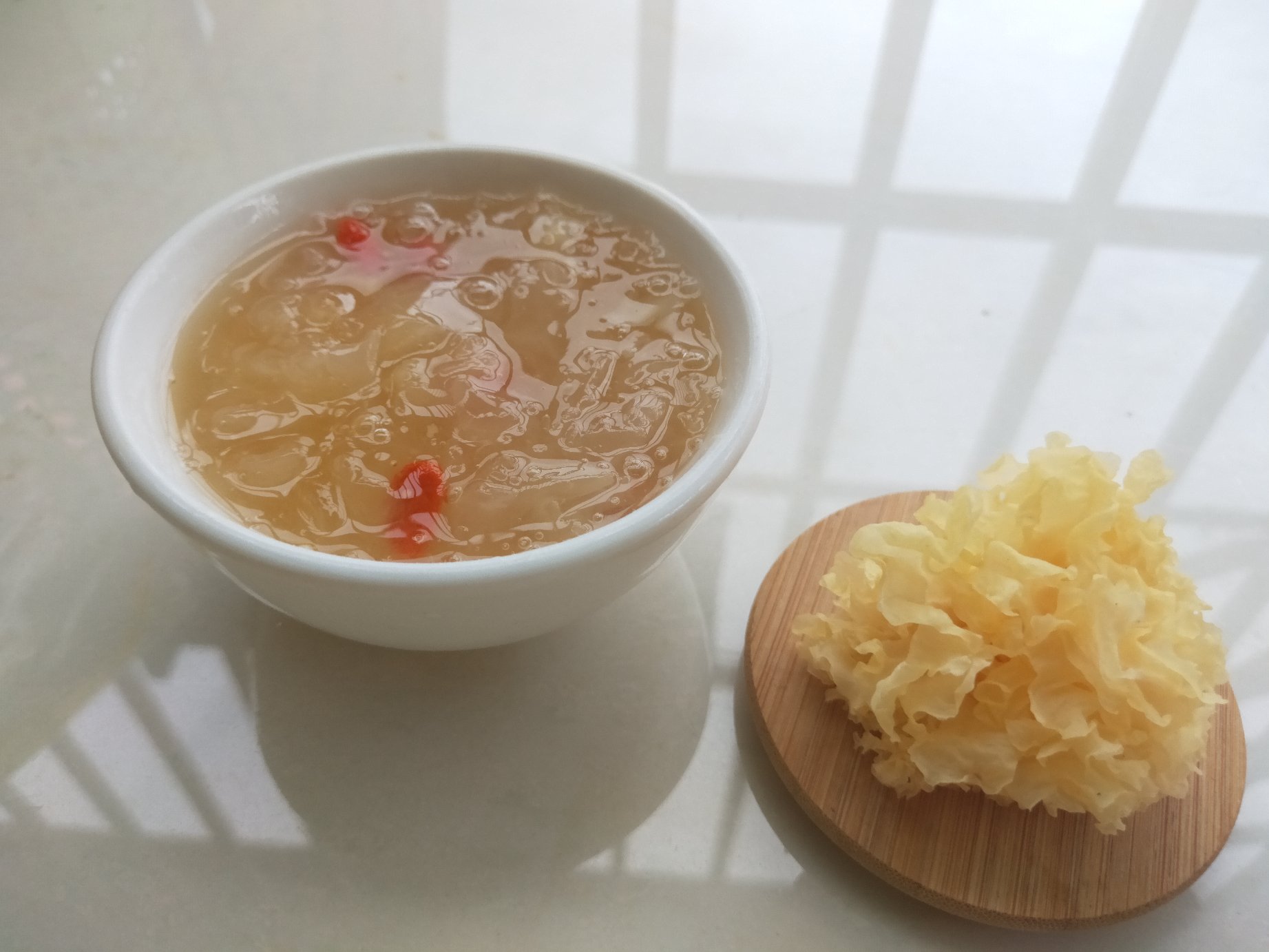 一碗热气腾腾的百合银耳莲子羹盛放在瓷碗中，汤色清亮，食材丰富