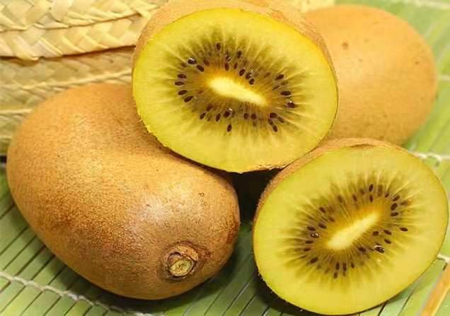 一颗切开的黄心猕猴桃,展示其金黄色果肉和新鲜多汁的质地 黄心猕猴桃特写