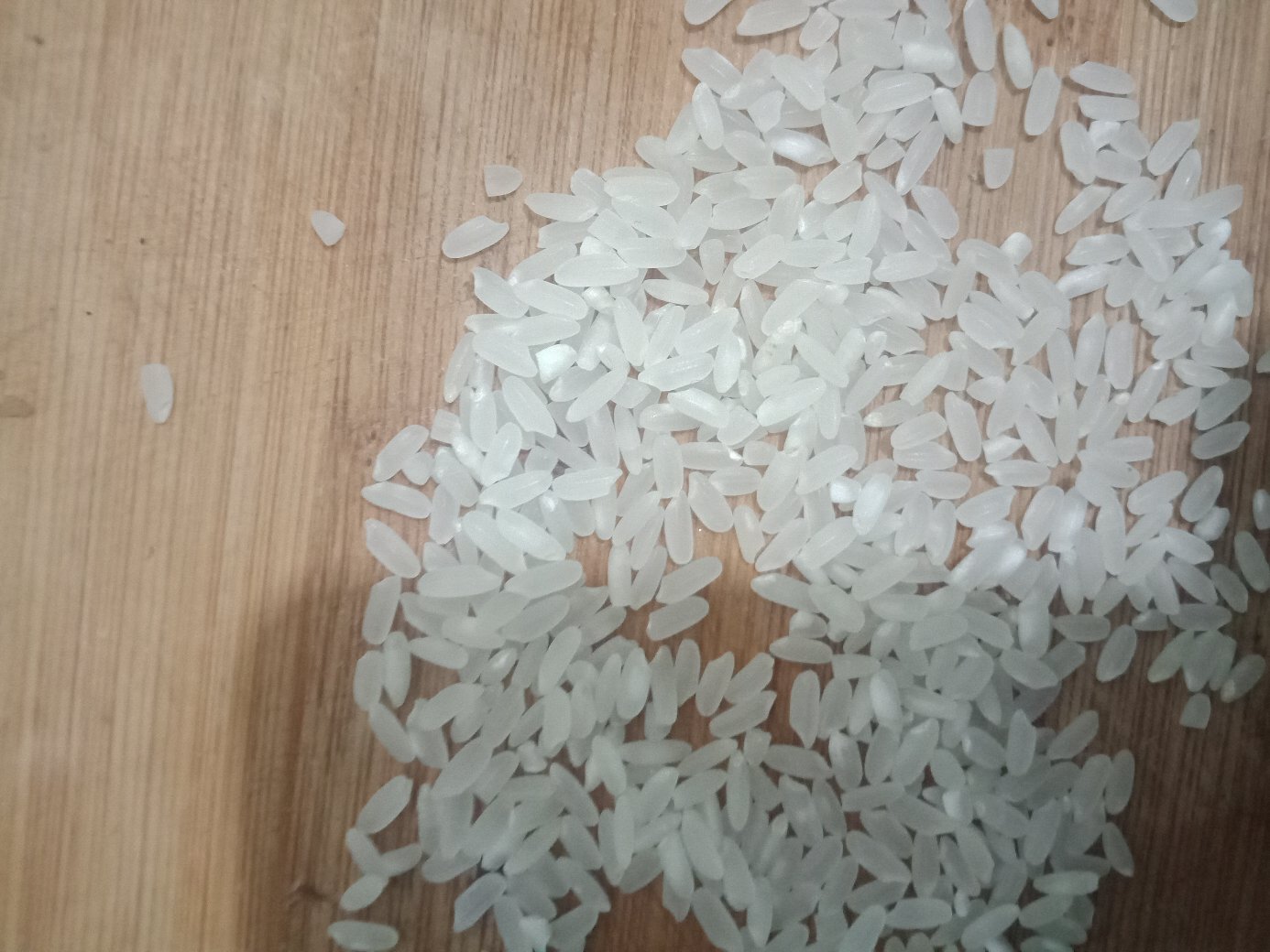 高清微距镜头拍摄的柴火大院长粒香大米干米样本,米粒细长饱满,呈半透明状,表面光滑有光泽,排列整齐,背景为深色木质托盘,突出米粒的纯净质感 长粒香大米特写