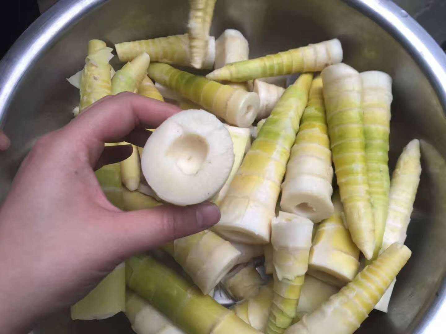 木质砧板上摆放着三种不同做法的雷竹笋菜肴:左边是清炒雷竹笋片,色泽清亮;中间为雷竹笋炖排骨汤,汤色乳白;右边是凉拌雷竹笋丝,配有红椒丝和香菜点缀,整体呈现健康饮食风格 厨房中雷竹笋的多种烹饪方式展示