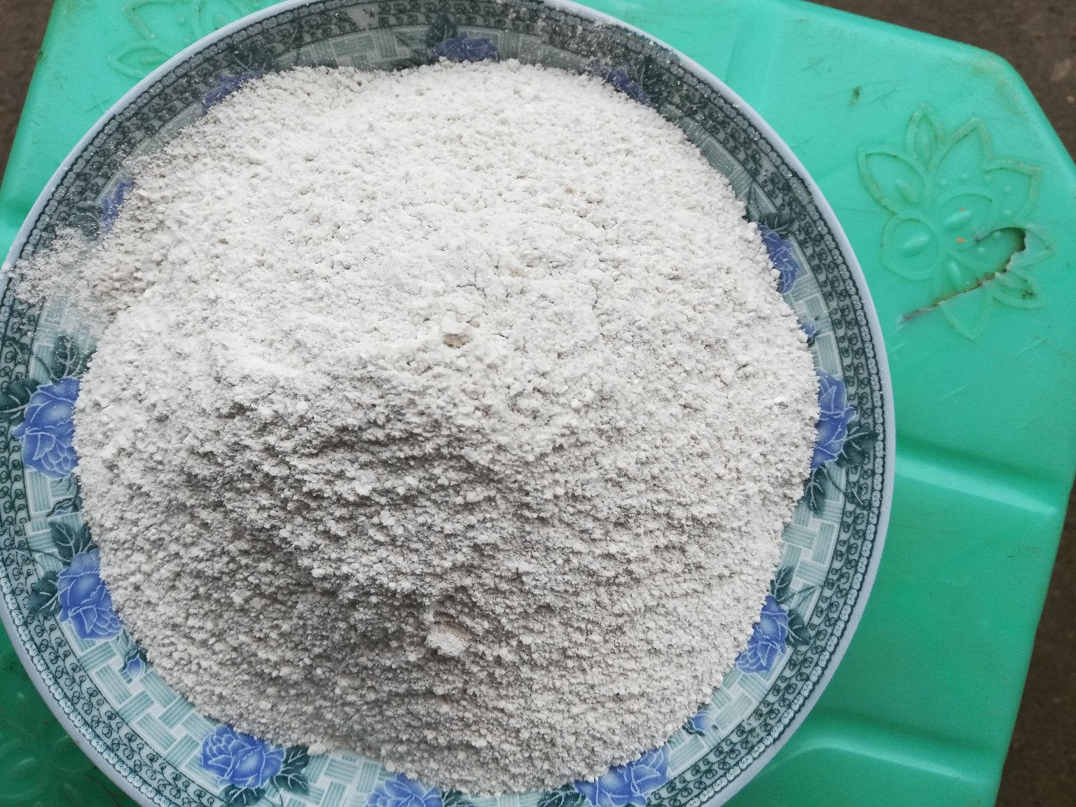 白色陶瓷碗中盛有淡黄色葛根粉糊,旁边放置木质搅拌勺,背景为厨房台面,左侧摆放密封玻璃罐装野生葛根粉,标签清晰可见‘野葛根粉’字样 厨房中冲泡葛根粉的场景