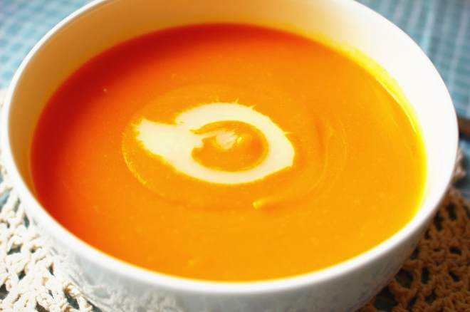 一道精致的奶油南瓜汤,汤体浓稠,表面撒有香草和橄榄油装饰 奶油南瓜料理