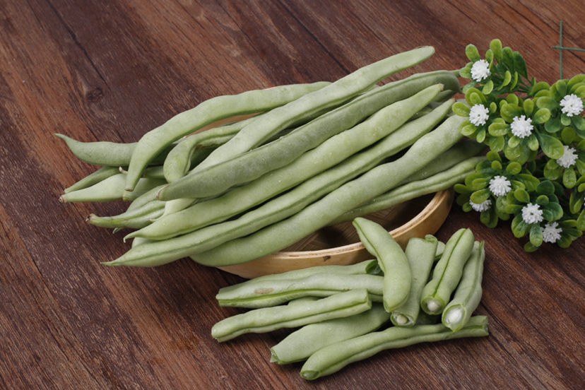 一盘清炒红菜苔摆放在木质餐桌上,颜色鲜亮,菜叶翠绿带紫红,菜梗脆嫩,旁边配有白米饭和简单的调味料,展示出家常健康饮食的美感 红菜苔烹饪成品图