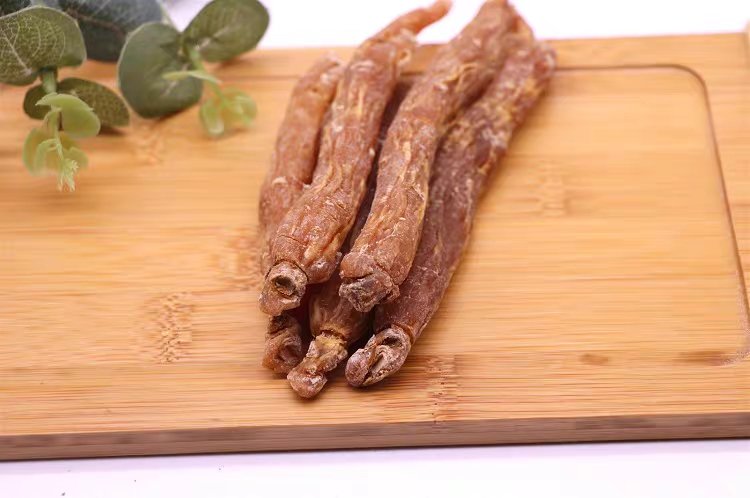 木质砧板上摆放着刚切好的淡黄色鲜人参薄片,旁边是一锅正在慢炖的鸡汤,热气腾腾,锅边配有枸杞、红枣等辅料,整体画面温馨自然,体现健康养生的生活方式 家庭厨房中使用鲜人参制作养生汤品的过程特写