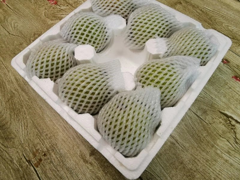 莱阳梨标准化礼盒包装,印有国家地理标志图案和二维码溯源标签,工作人员正在扫描二维码查看种植档案,背景为现代化分拣车间,传送带上梨果按大小分级 莱阳梨包装与溯源系统