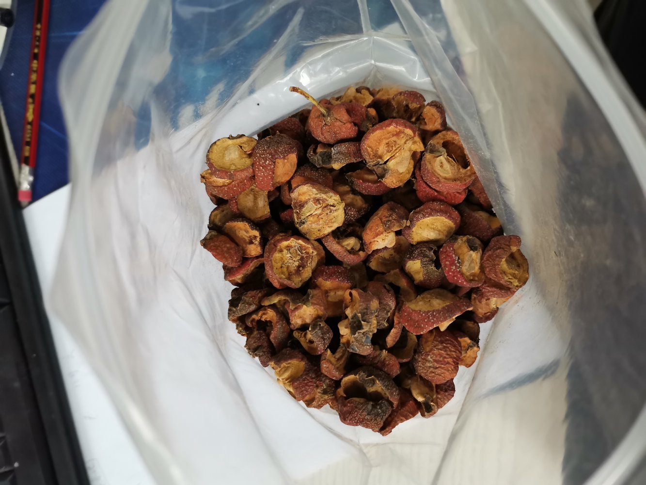 两个透明玻璃罐并列摆放,左罐装满深红色山楂干片,右罐为浅黄色西洋参薄切片,标签分别标注‘山东大山楂’和‘五年生吉林西洋参’,背景为厨房储物架,体现家庭健康食材管理场景 山楂与西洋参储存包装展示图