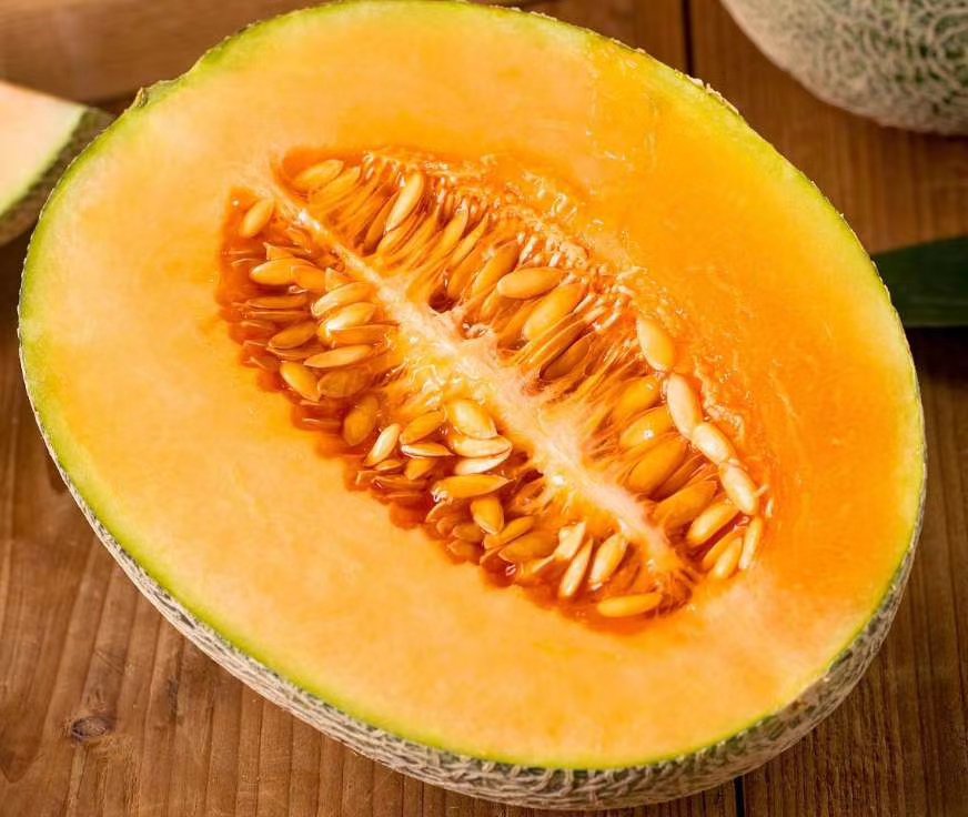 哈密瓜切开后露出橙黄色果肉和丰富汁水