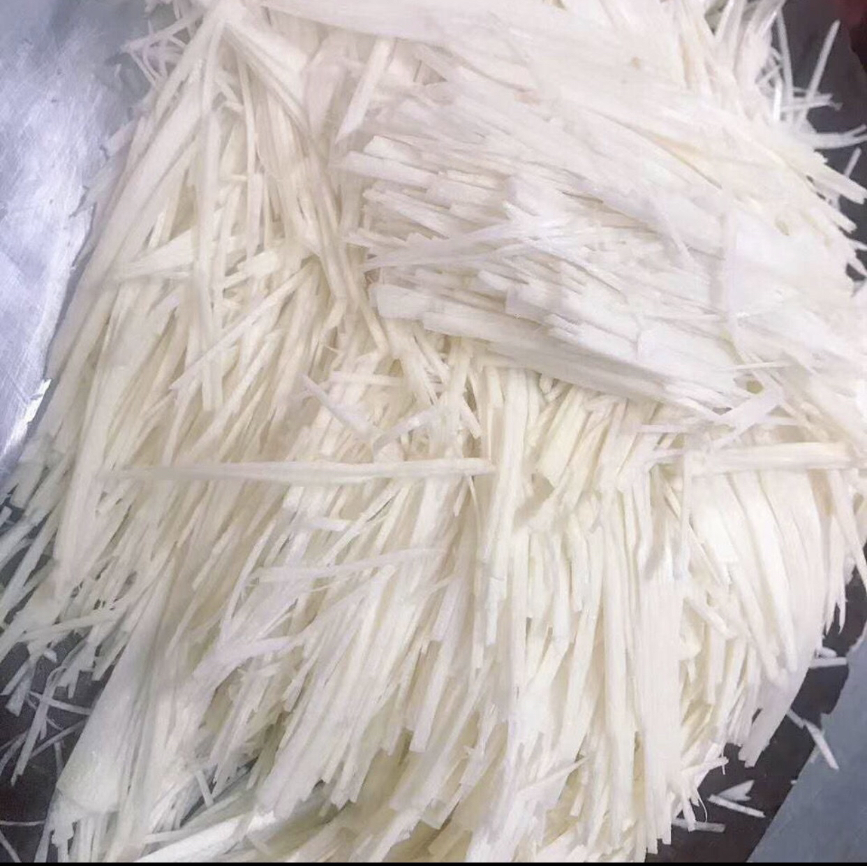 安全食用竹笋示范图:焯水后切细的笋丝特写,色泽嫩黄、纹理清晰、无粗硬纤维,搭配常见辅料,传递'正确处理即安全'的核心信息 中式厨房砧板上整齐码放焯水后的嫩黄色竹笋丝,旁边配蒜末、青椒丝,体现安全加工后的可食形态