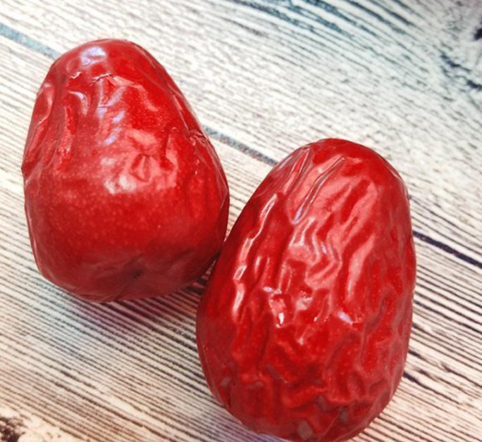 展示新鲜采摘的和田大枣,果实饱满,颜色深红,背景为新疆和田的自然风光 和田大枣特写