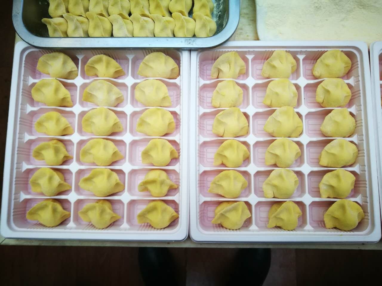 金黄饱满的玉米馅饺子摆盘,表面略带油光,背景为中式餐桌 玉米馅饺子成品图