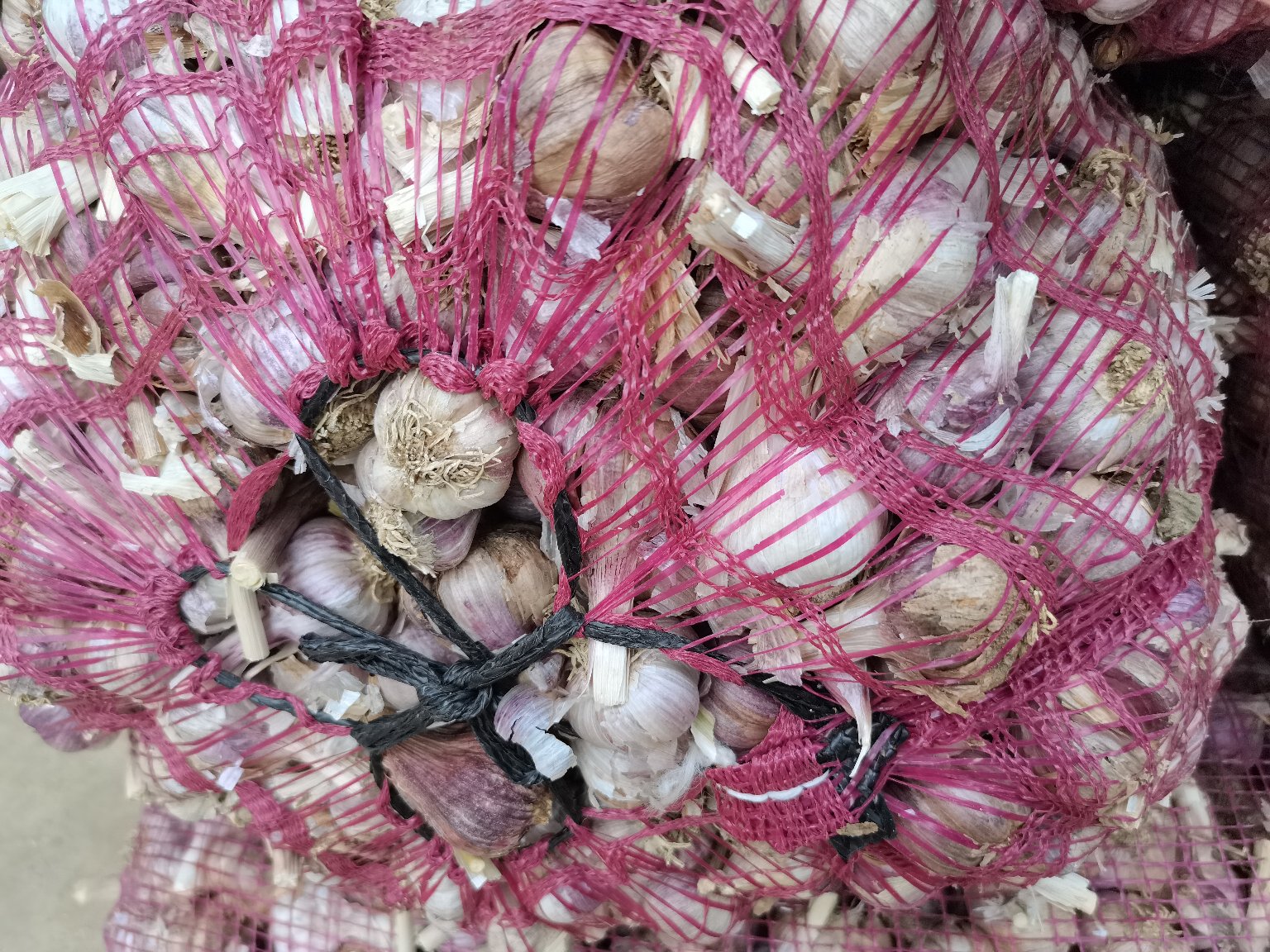 一盘晶莹剔透的宝菜蒜米,颗粒均匀,呈乳白色,散放在竹制小碟中,背景为厨房操作台,旁边有新鲜大蒜、玻璃瓶和调料罐,展现天然健康的食品氛围 宝菜蒜米产品特写