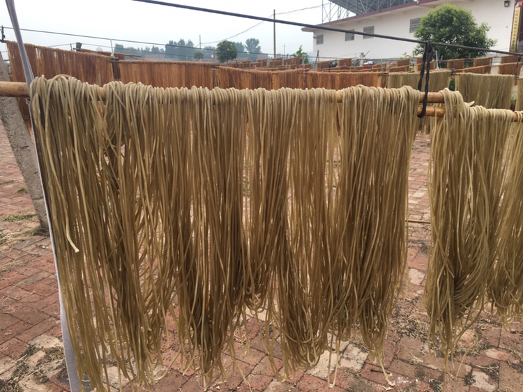 三款不同粉丝包装并列展示:左为标注‘100%蚕豆淀粉’的绿色包装产品,中间为混合淀粉粉丝,右为普通红薯粉丝;箭头指向配料表细节,突出成分差异 市售粉丝包装对比图
