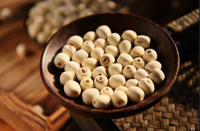 湘潭白莲子全产业链产品陈列:左侧为真空包装特级通心白莲(米粒饱满圆润、色泽如玉),中部为冻干莲子脆片(金黄半透明、形态完整),右侧为GABA富集莲子粉(细腻乳白色粉末,附检测报告二维码标签),背景可见‘国家地理标志产品’与‘有机产品认证’标识 湘潭白莲子深加工产品矩阵展示