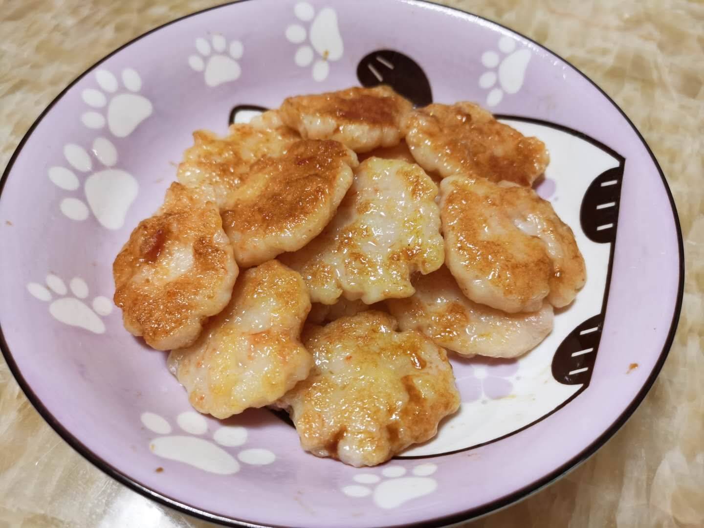 展示锅中正在煎制的小葱虾皮饼,表面呈金黄色,香气四溢 小葱虾皮拌饼子煎制过程