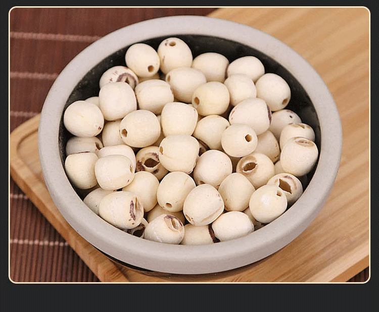 冰糖湘莲羹成品展示 一碗晶莹剔透的冰糖湘莲羹盛放在白色瓷碗中,表面漂浮着几粒红枸杞和金黄色桂花,背景虚化