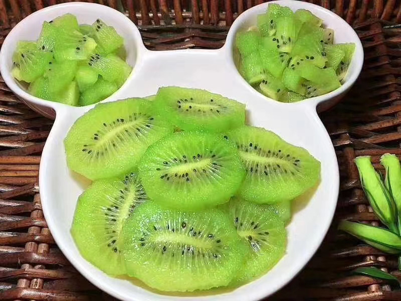 红心猕猴桃制作的水果塔摆盘艺术,展现高端甜点风格与色彩搭配美感 白色瓷盘上的红心猕猴桃水果塔,顶部由放射状排列的红色果片组成花朵造型,边缘点缀绿色薄荷叶