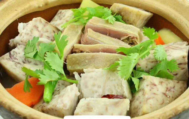 一盘刚从碗中倒扣出来的走油肉扣香芋,呈现出整齐的同心圆排列,肉片红亮油润,香芋呈淡紫色,表面泛着晶莹酱汁光泽,旁边配有绿色香菜点缀 走油肉扣香芋成品倒扣出锅图